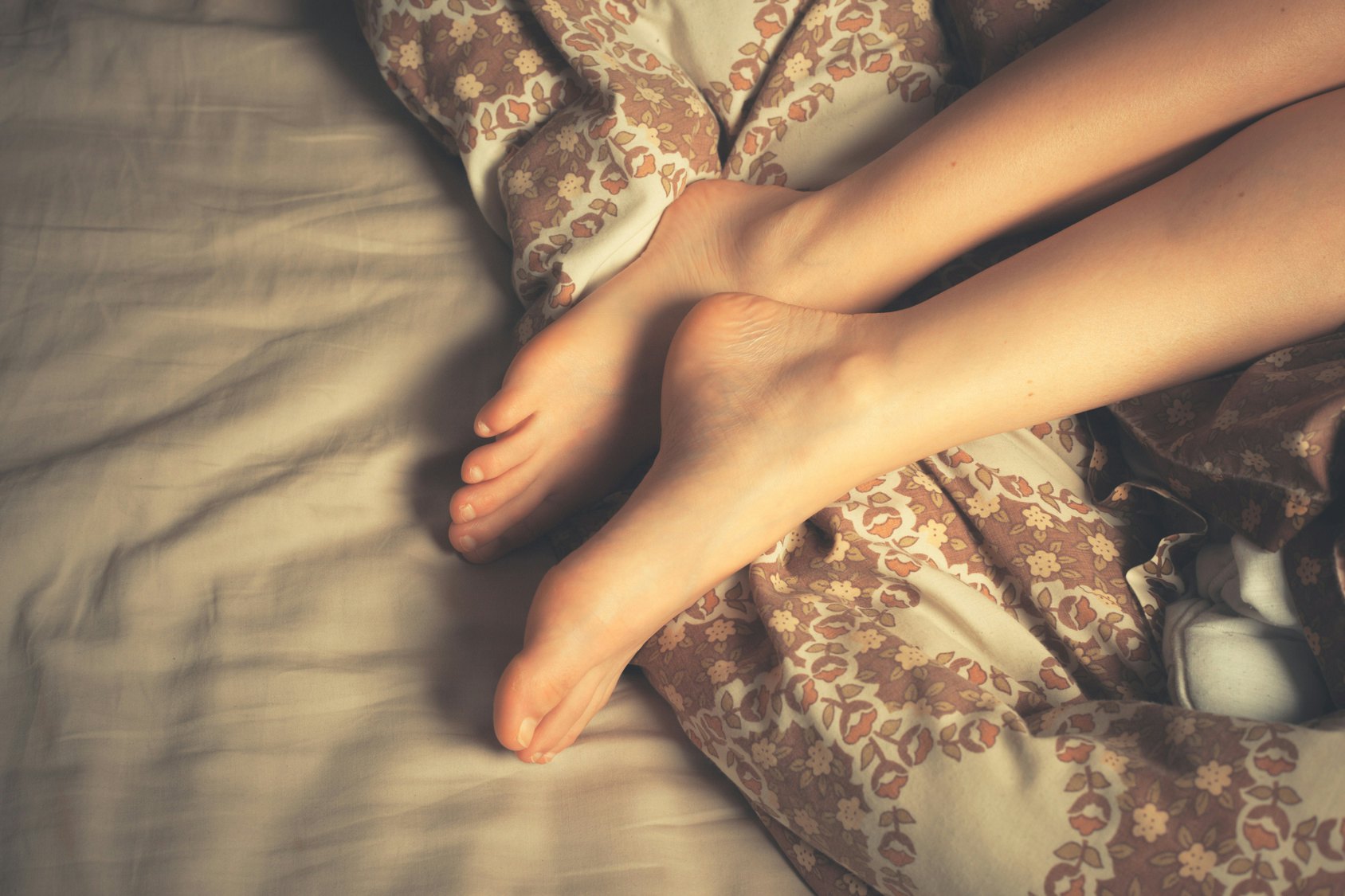 Рыжая бестия в сексуальном белье хвастается попой и ножками в чулках на кровати