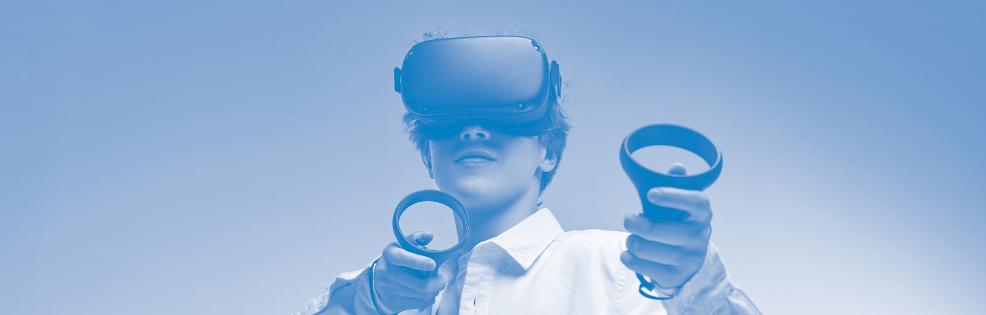 young boy play VR games in virtual reality helmets on bright colourful background, hold controllers ...