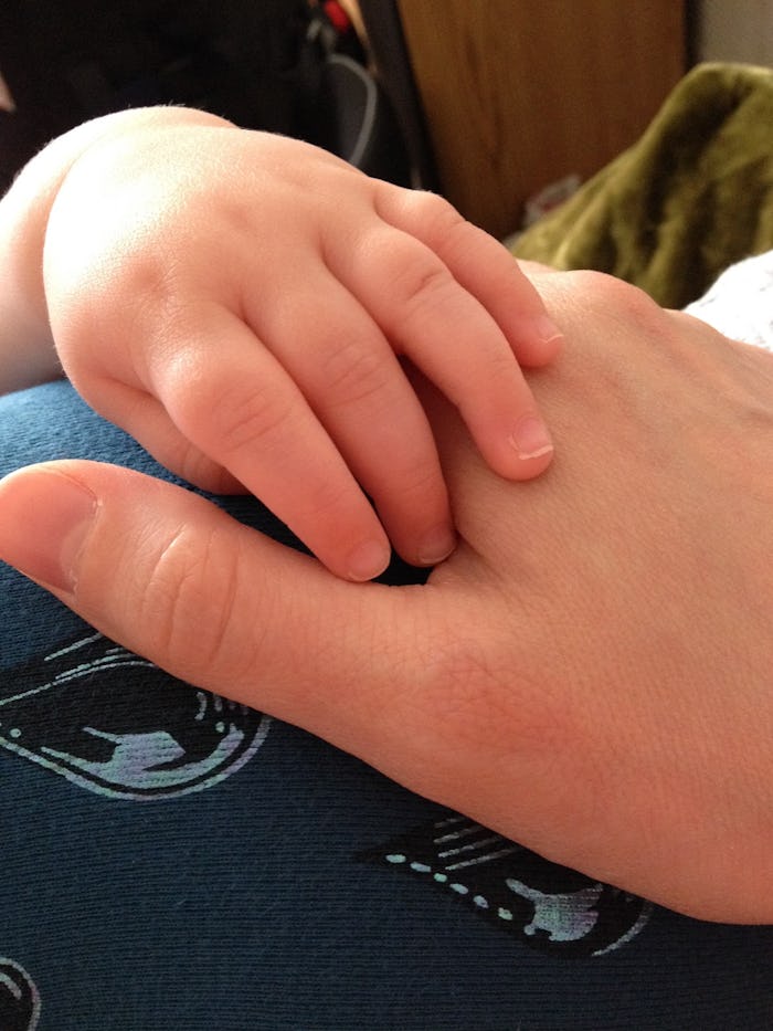 Baby's hand resting on her mother's hand