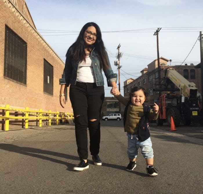 Mom and her toddler holding hands while walking down the street.