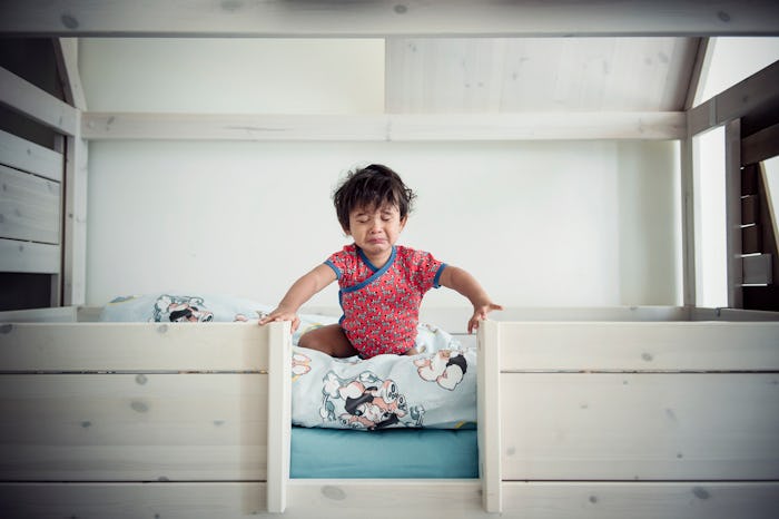Toddler sitting up in bed during sleep training