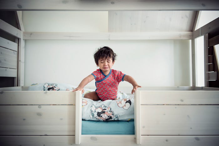 Toddler sitting up in bed during sleep training