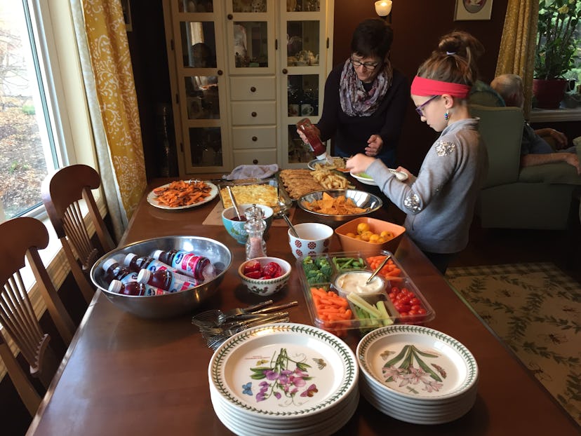 A grandmother and granddaughter serving a table for a Thanksgiving dinner