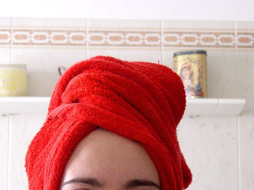 A woman wearing a red tee-shirt towel as a cap