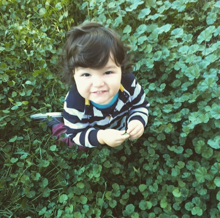 A mexican-american child sitting in the grass