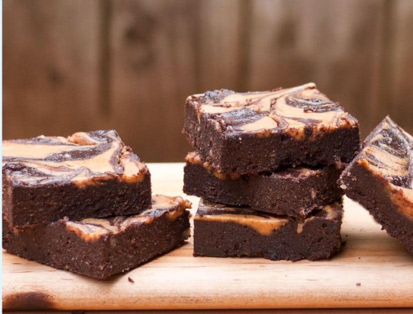 Peanut Butter Swirl Brownies stacked on a wooden cutting board