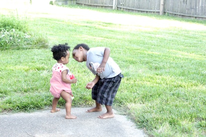 Little brother and sister having fun with each other in the backyard