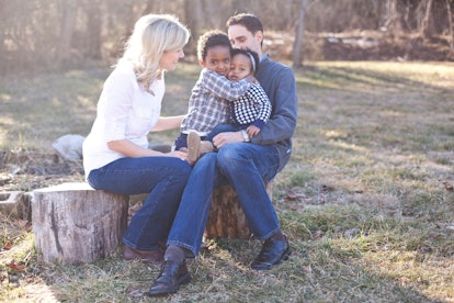 Happy family posing in the forest where parents are visibly happy, and their kids are hugging each o...