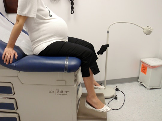 Pregnant woman sitting in an examination chair at the doctors office