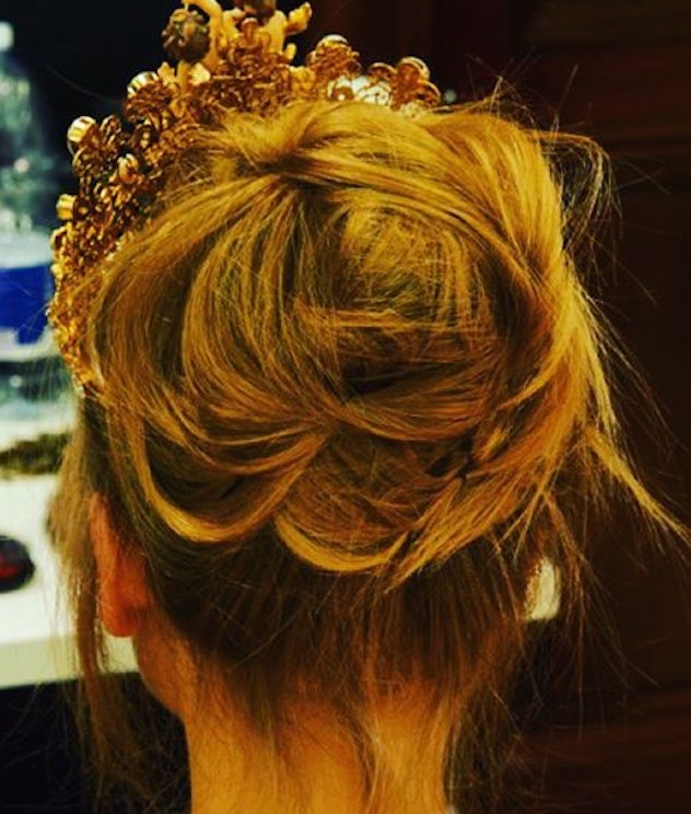 A woman with the messy bun and crown on her head
