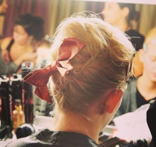 A woman with messy up-do and pink bow 