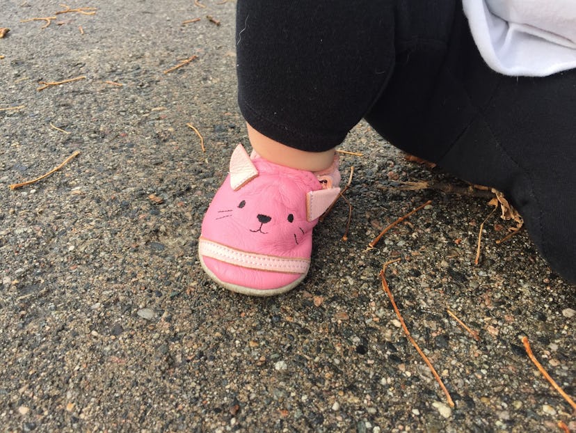  Close shot of toddler’s pink shoes that look like kitties.