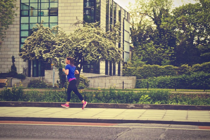A woman in sportswear running on the street.