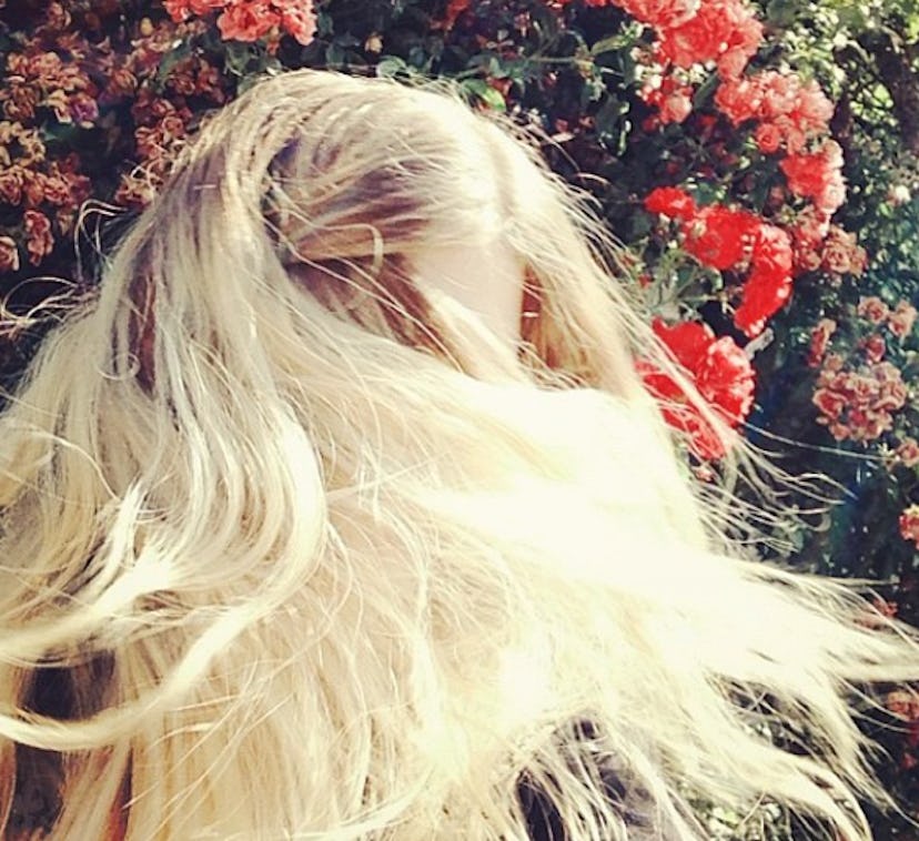 A blonde girl covering her face with her hair