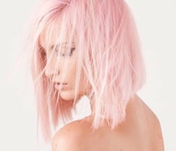 A side profile of a woman with a pink asymmetric bob