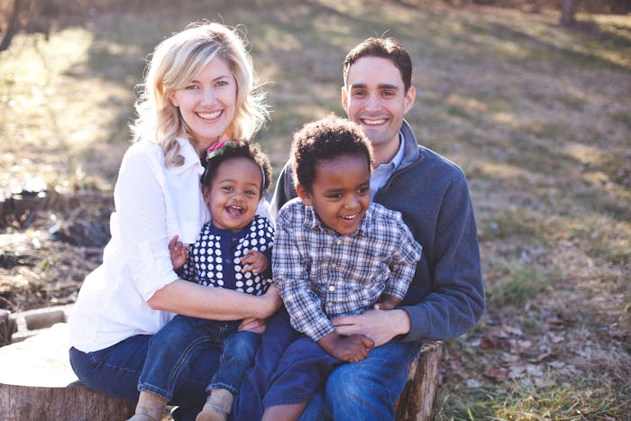 Lauren Casper with her partner and their two kids smiling and posing