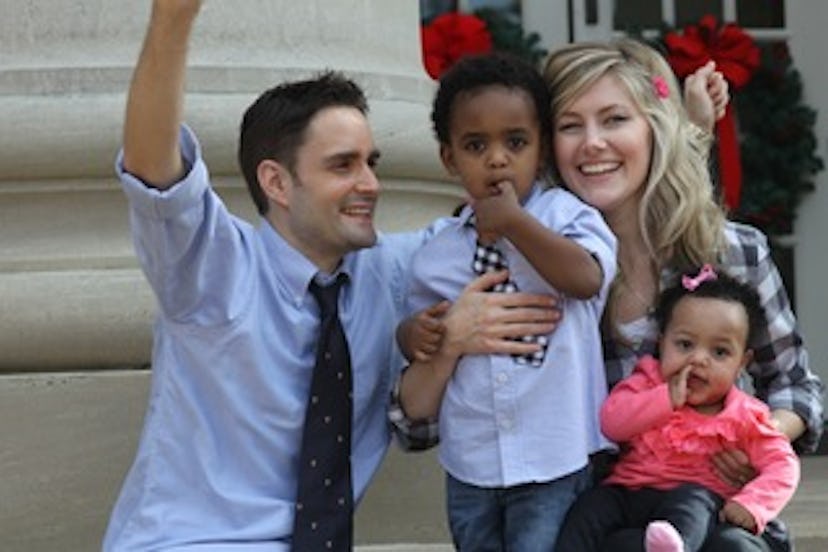 Lauren Casper and her partner smiling while posing for a photo with their adopted kids