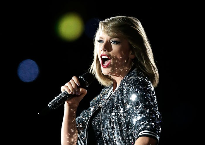 Taylor Swift holding a microphone and singing during her concert