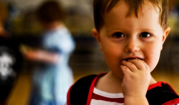 A child who is a picky eater with his hand in has mouth