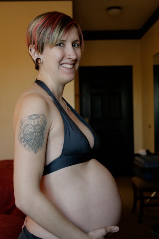 Skinny-shamed pregnant woman posing in a black bra
