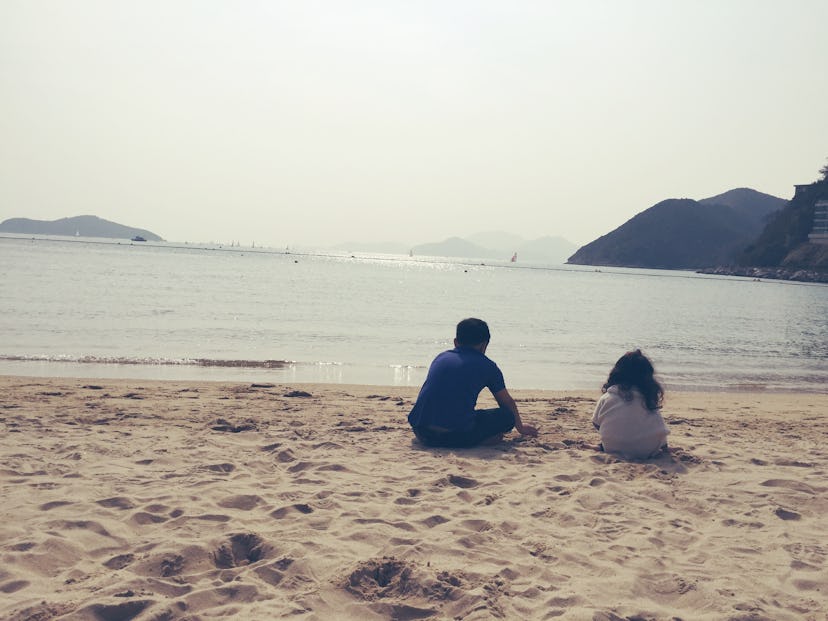 A boy and a girl sitting on the beach 