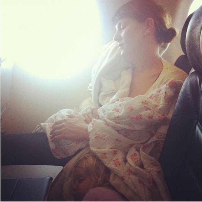 A mother breastfeeding her baby while on a plane.