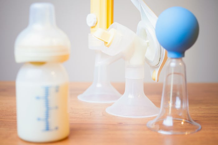 A bottle of milk and three breast pumps on the side