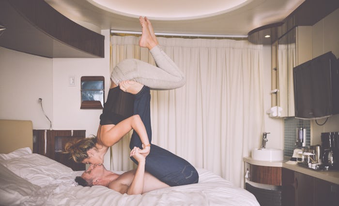 Man holding woman up with his legs as they kiss in an acrobatic pose