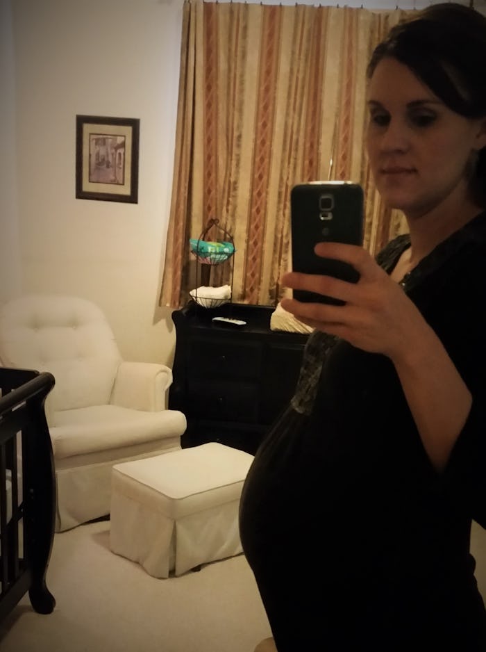 Pregnant woman taking a selfie in the mirror