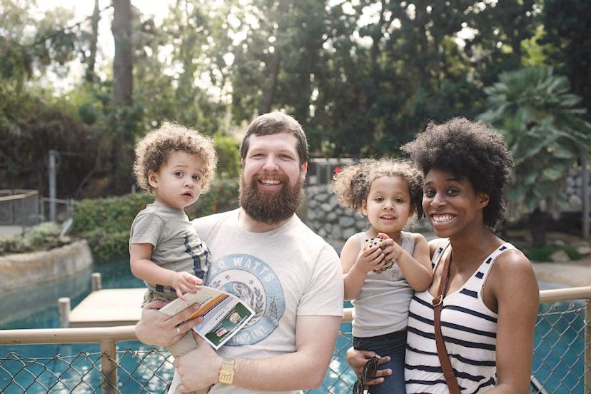 A divorced couple holding their children and posing for the picture near the pool