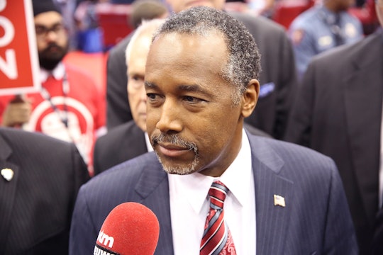 Ben Carson speaking into a reporter's microphone