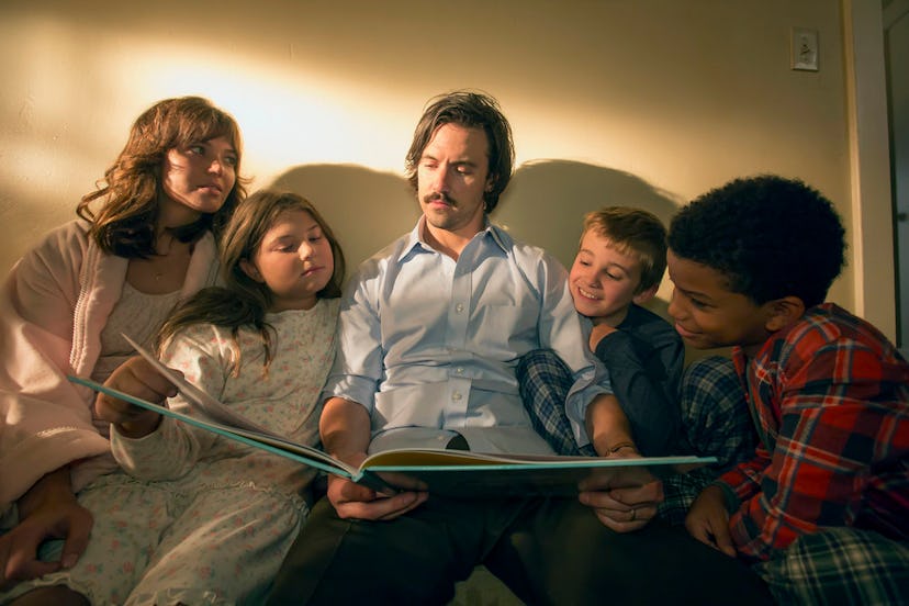 A scene from the series This is Us where Jack is reading a book to his three children and wife