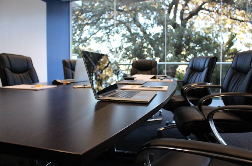 The inside of a conference room with a laptop on a large table