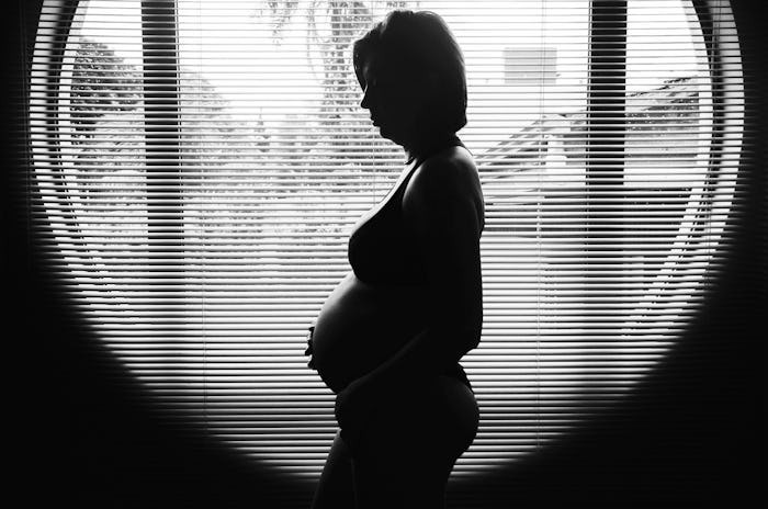 A side-view of a pregnant woman who is scared of late-term abortions