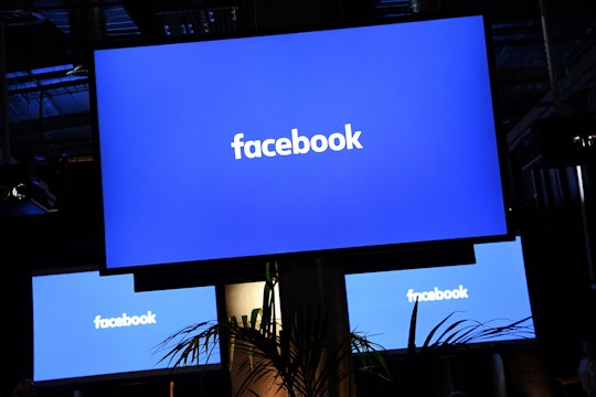 A white Facebook logo on a blue background shown on three monitors depicting its censorship of a Bre...