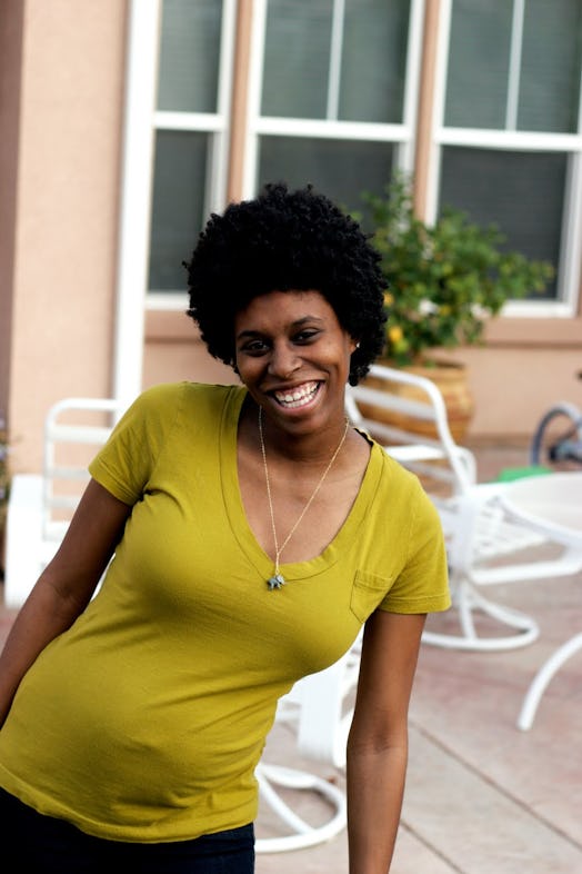 A pregnant woman smiling while posing for a photo