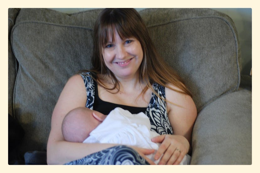 Michelle Myer holding her newborn baby while sitting on a couch