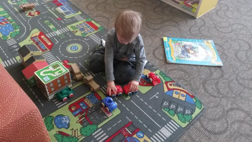A toddler playing with his car toys