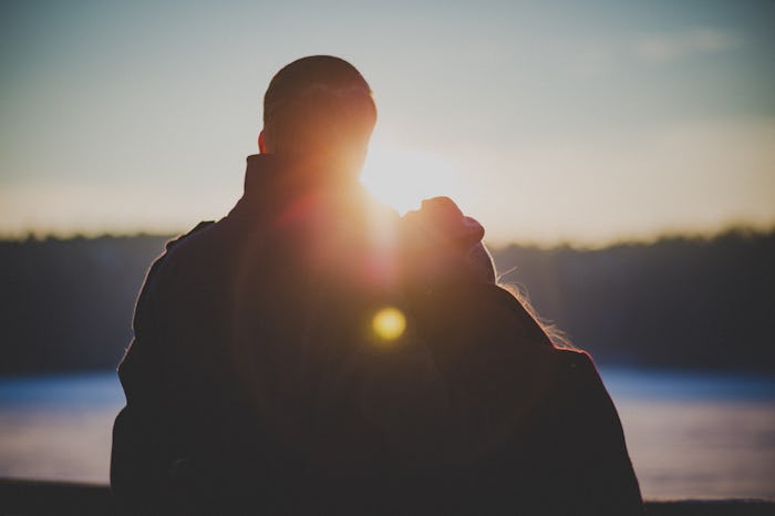 Two grieving parents looking into the distance at a sunset