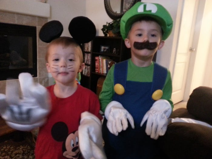 Two children dressed up for halloween, one is micky mouse and the other luigi