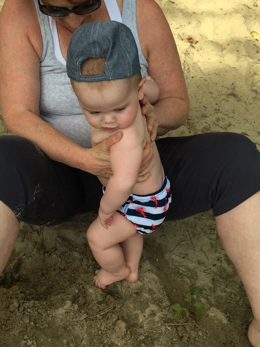 A mother holding her baby boy while having fun on the beach