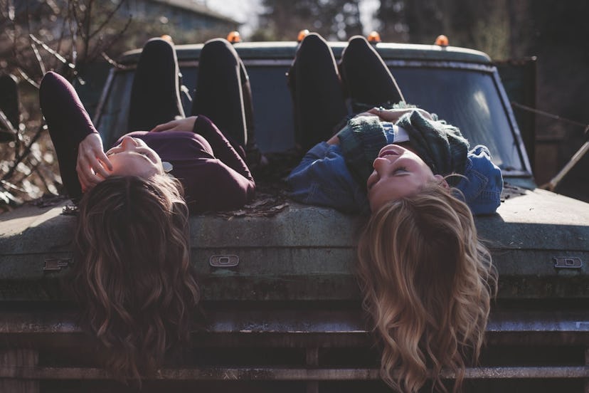 Two girls lying on a truck