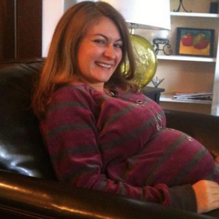 Author Megan Zander pregnant, sitting on a sofa.