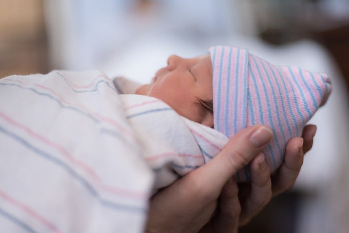 A mother holding a newborn baby during its first night at the hospital