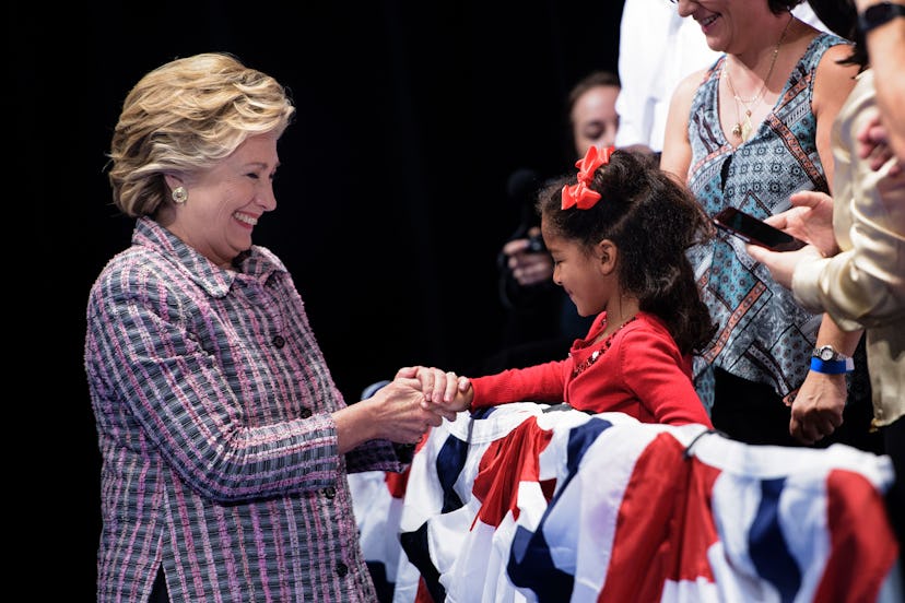 Hillary Clinton shaking hands with a little girl