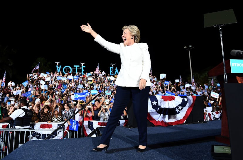 Hillary Clinton wearing a white blazer and black pants