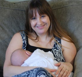 Michelle Myer smiling while holding her newborn baby