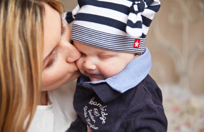 Millennial mother kissing her son