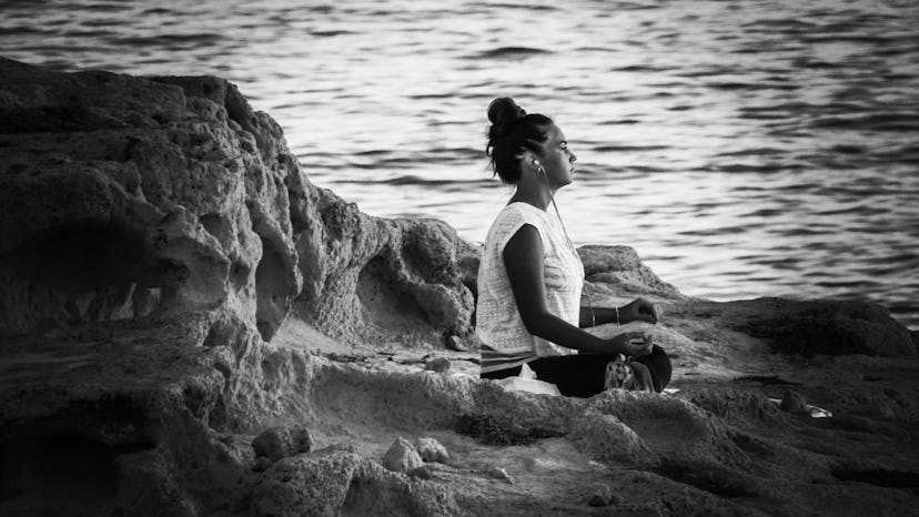 A woman meditating on a beach