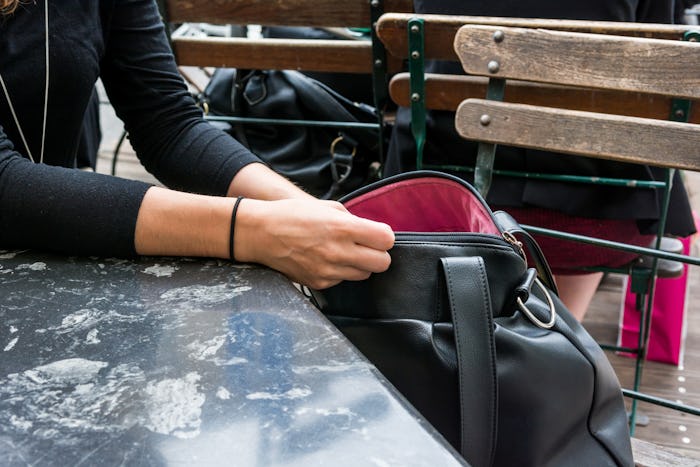 A woman with mommy brain looking through her purse while at a cafe